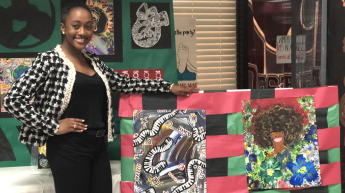 DeJoan Mitchell displaying her art work she did at Destrehan High School.
