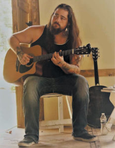 Dustin Cole playing his guitar.